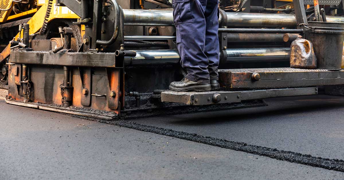 wright-construction-company-How-to-Tell-When-Your-Business-Needs-Parking-Lot-Resurfacing Commercial parking lot showing signs that indicate resurfacing may be needed.