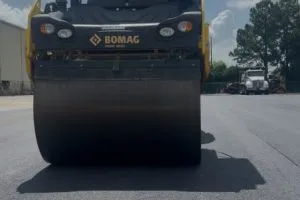 Asphalt roller compacting new pavement at Kohler manufacturing facility