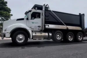 Dump truck delivering asphalt for commercial paving project at Kohler facility