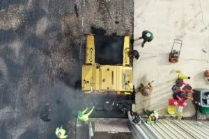 Aerial view of asphalt paving crew resurfacing commercial parking area at Orlando Health