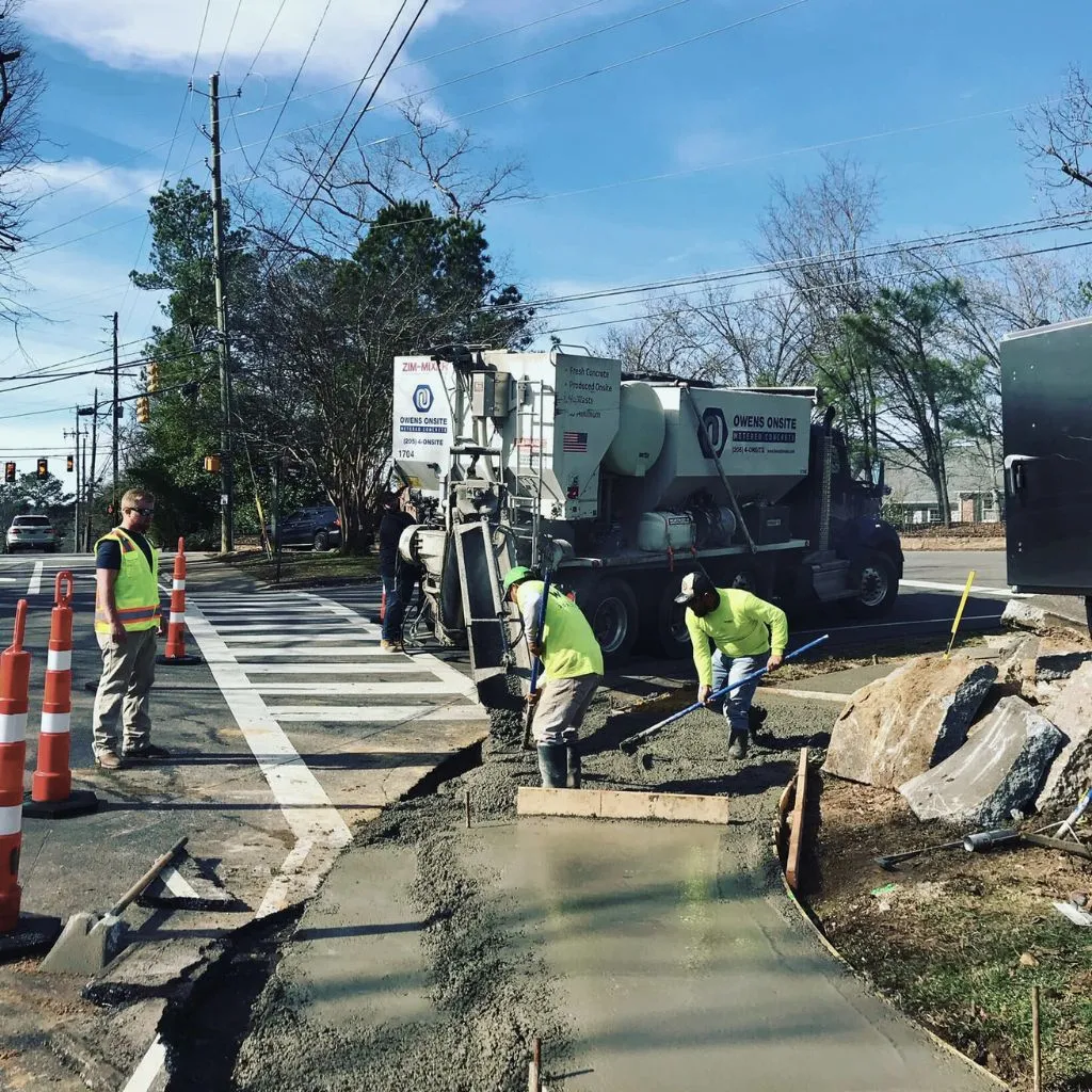 Crew pouring and finishing concrete ADA curb ramp at signalized intersection – Wright Construction